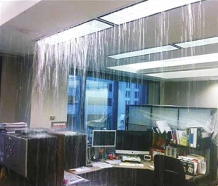 Water pouring through ceiling in an office setting