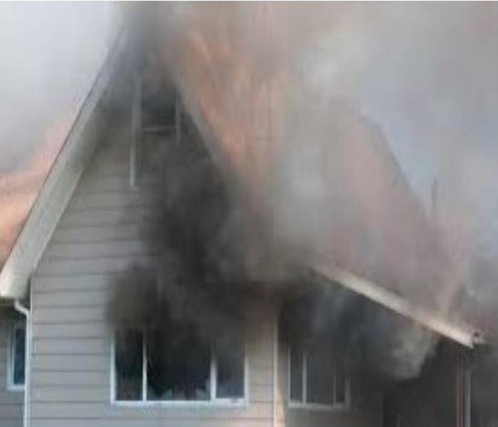 Soot and smoke billowing from a homes windows